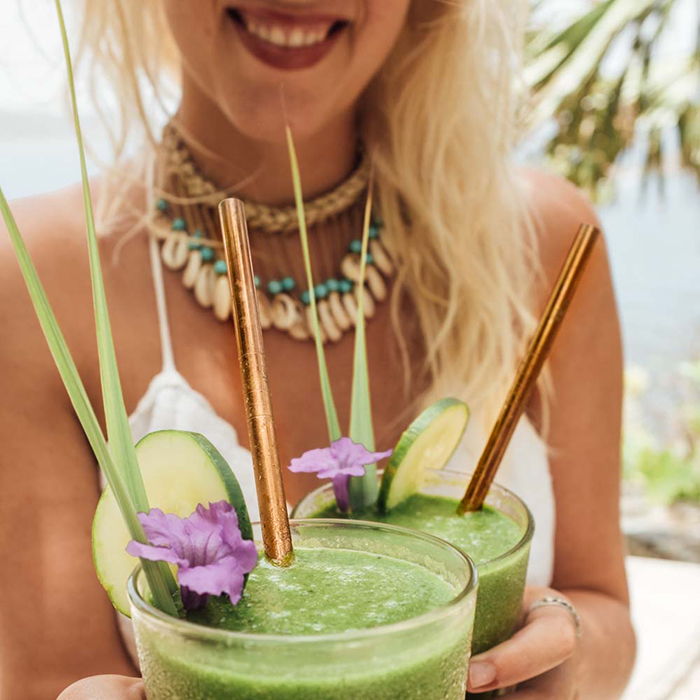 Woman holding two smoothies with plastic free straws