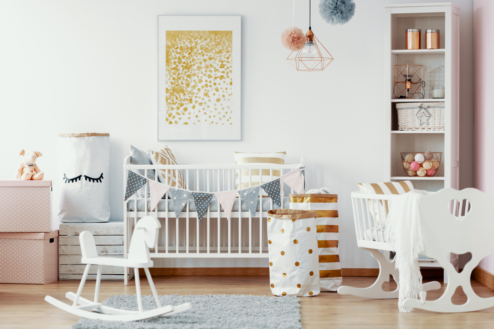 Cozy nursery room in pastel colors with white furniture