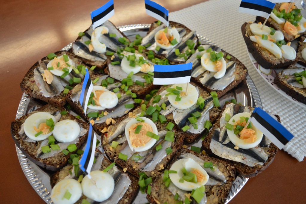 Sprats on slices of rye bread decorated with boiled eggs and Estonian flags