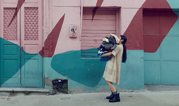 Woman holding a bunch of clothes for donations