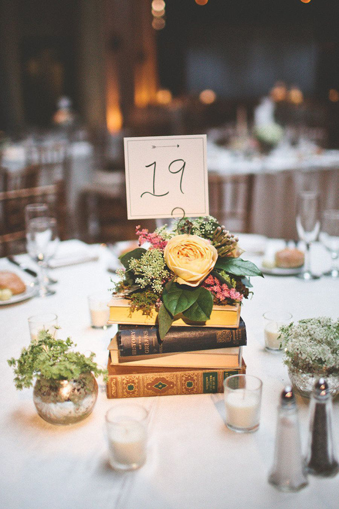 Unique wedding table decor with vintage books and flowers