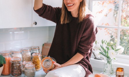 Woman standing in the kitchen with jar full of paste zero waste kitchen