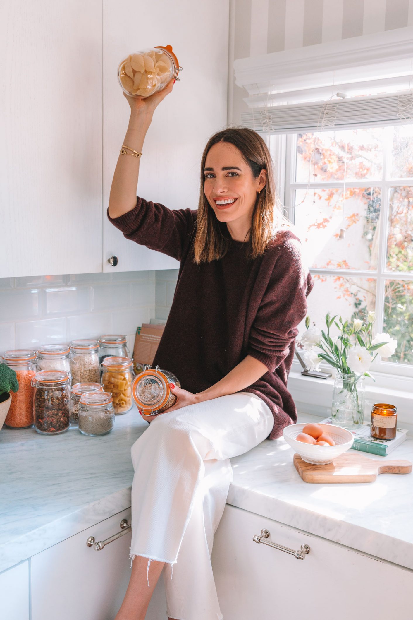Woman standing in the kitchen with jar full of paste zero waste kitchen