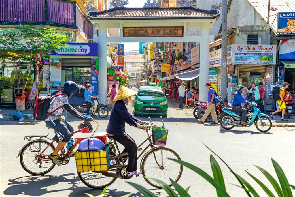 Crowded day in Vietnam with people cycling and shops around