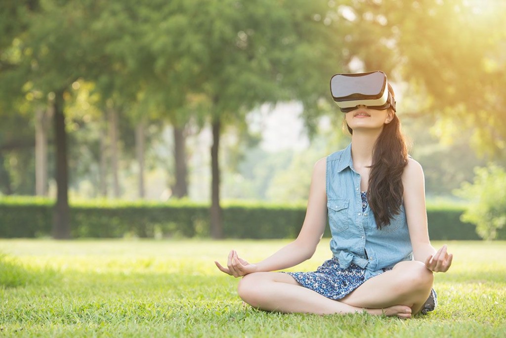 Girl sitting in a meadow but traveling to a different place through VR