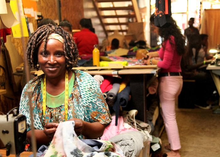 Afro american woman making Ethical clothes and smiling