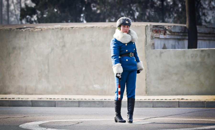 Young woman in North Korea guiding the traffic