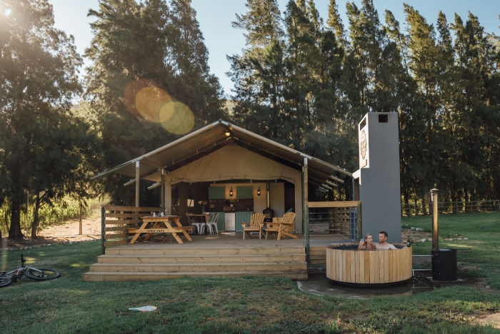 Glamorous glamping with a couple enjoying the jacuzzi outdoors