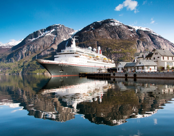 Cruise ship on a port with small houses and mountains around