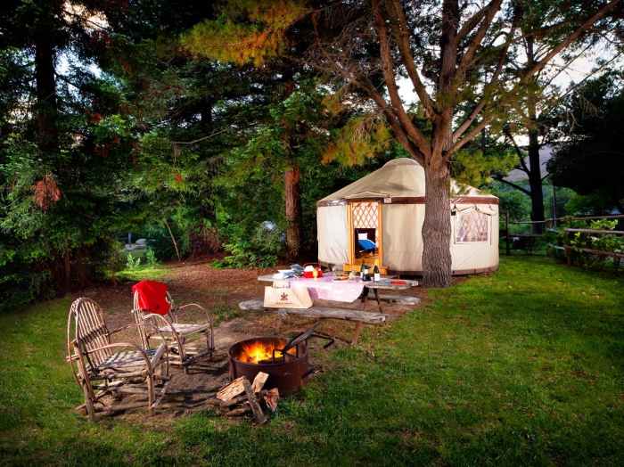 Hippie glamping tent with chairs in front and a campfire