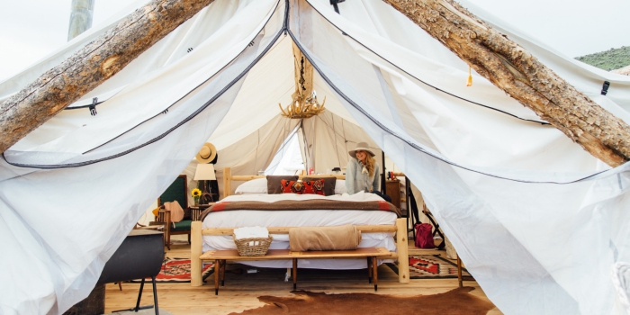 Luxury Glamping tent with wooden bed, vintage cushion, carpets and chandelier