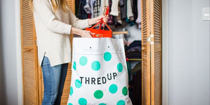 woman putting items into a big recycling bag