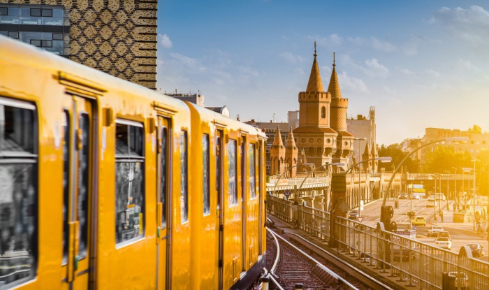 Yellow train passing by some big city in Europe