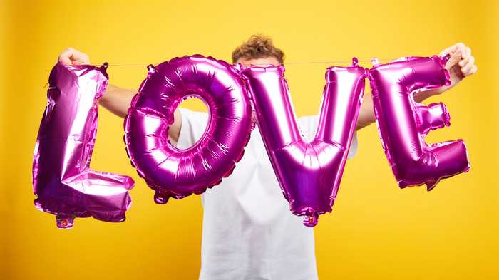 person holding large balloon with the word Love