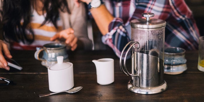 table with coffee cups and a brewer