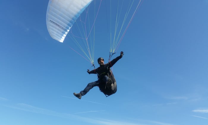 man flying in the air with a parachute