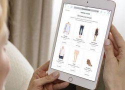 woman with a tablet choosing clothes from an online store