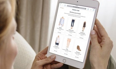 woman with a tablet choosing clothes from an online store
