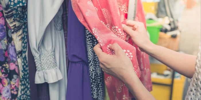 a hand touching a dress in a shop