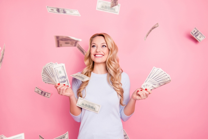 Money buy happiness young woman on a pink background with money 