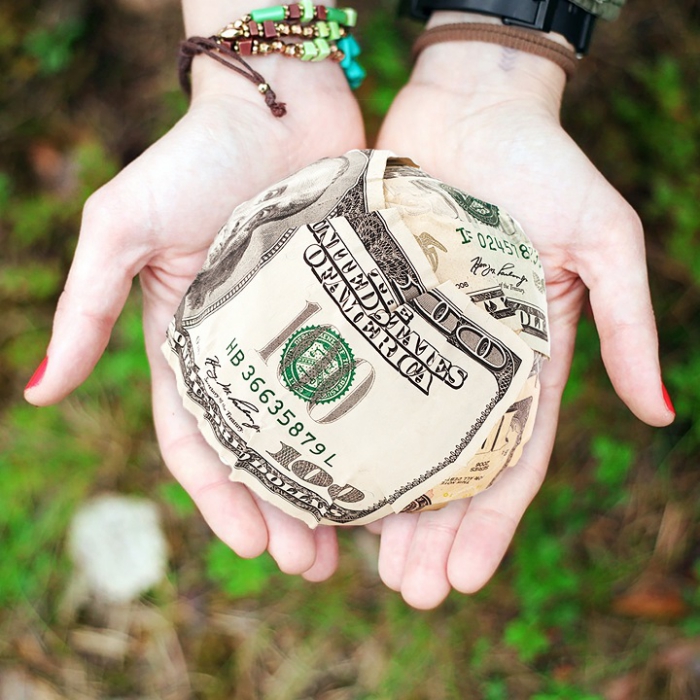 Woman with a ball of money in her hands