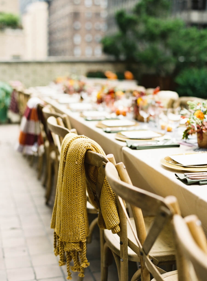 outdoor wedding table with cosy warm blankets on chairs