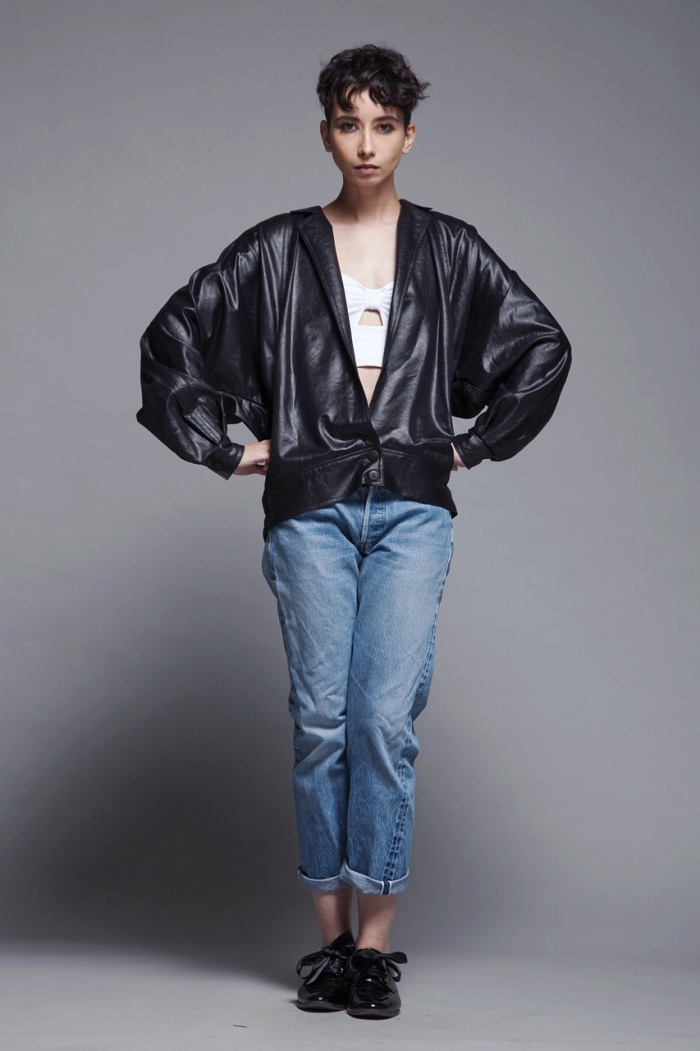 woman with oversize leather bomber jacket on grey background