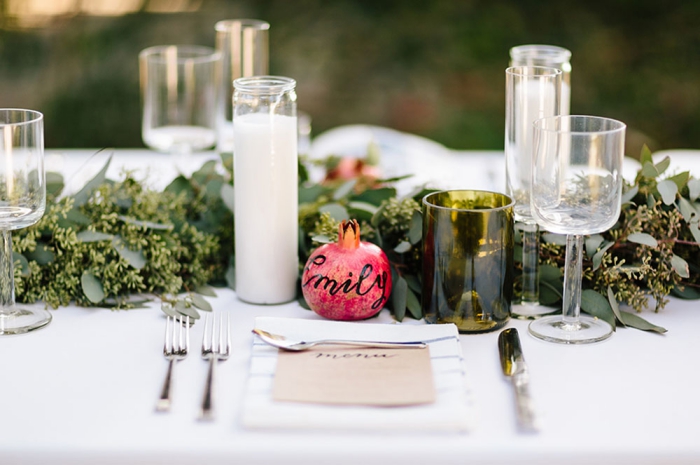 elegant fall wedding table with pomegranate place signs and candles