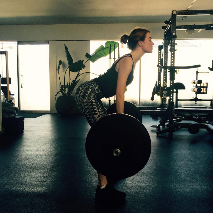 Emma Stone training in a gym lifting weights 