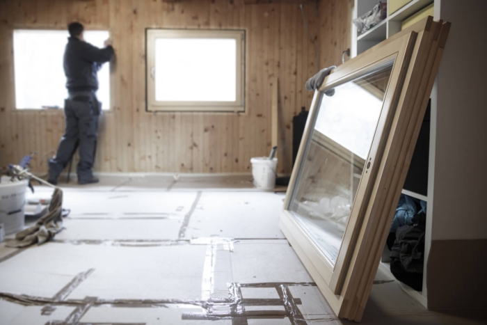 Man replacing old windows with energy-efficient new windows