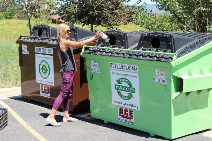 Woman throwing plastic in container to recycle