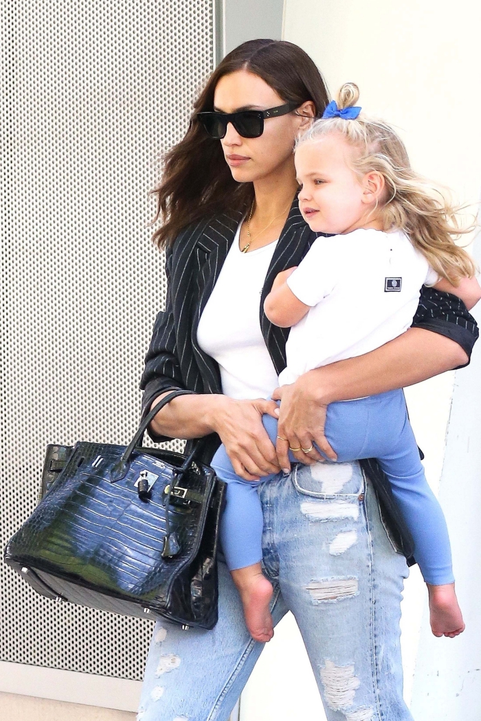 irina shayk walking outside with her daughter in hands