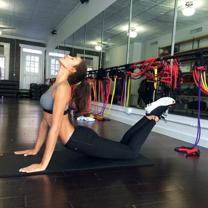 woman in sportswear in the gym on a mat exercising