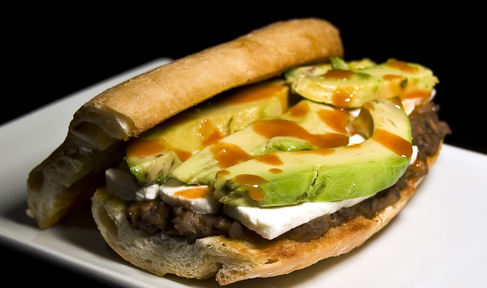 Mexican loncha sandwich with meat and avocado closeup