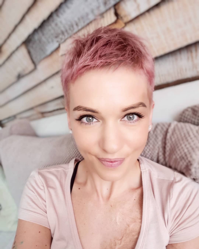 Woman with super short pink pixie light eyes on a wood background