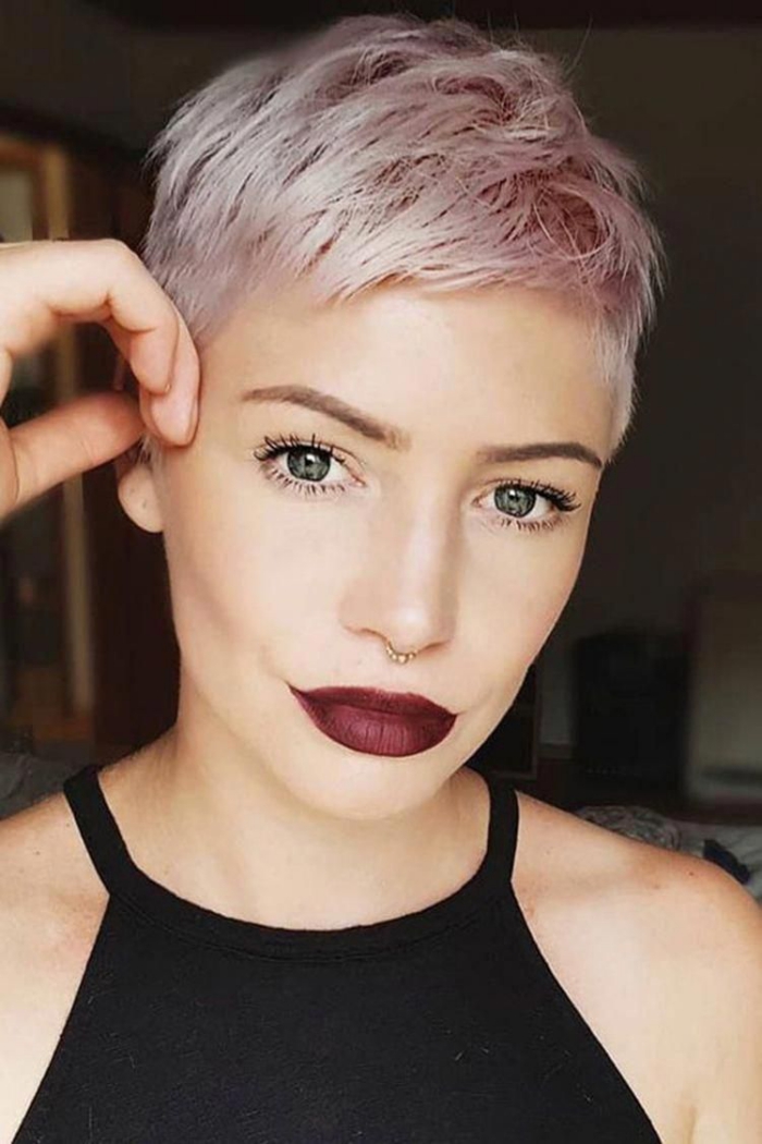 Woman with super short pink pixie hair looking in the camera deep red lipstick