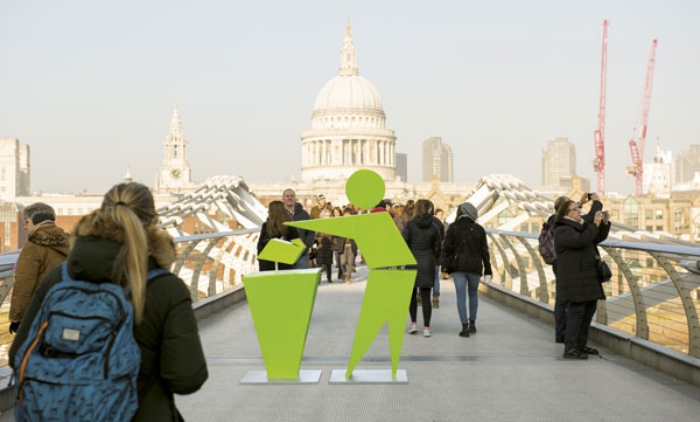  green Tidyman sign on bridge with people