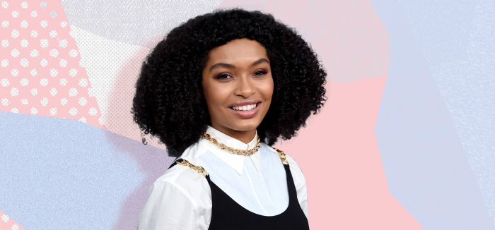 smiling woman dressed in black and white with dark curly hair 