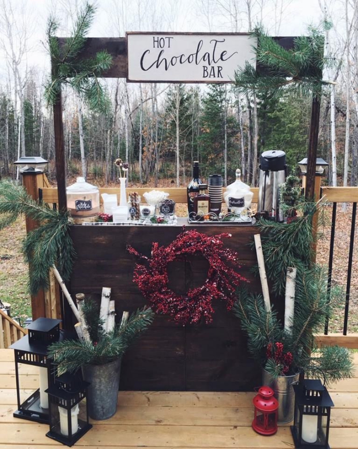 Outdoor wedding decor hot chocolate bar decorated with pine branches