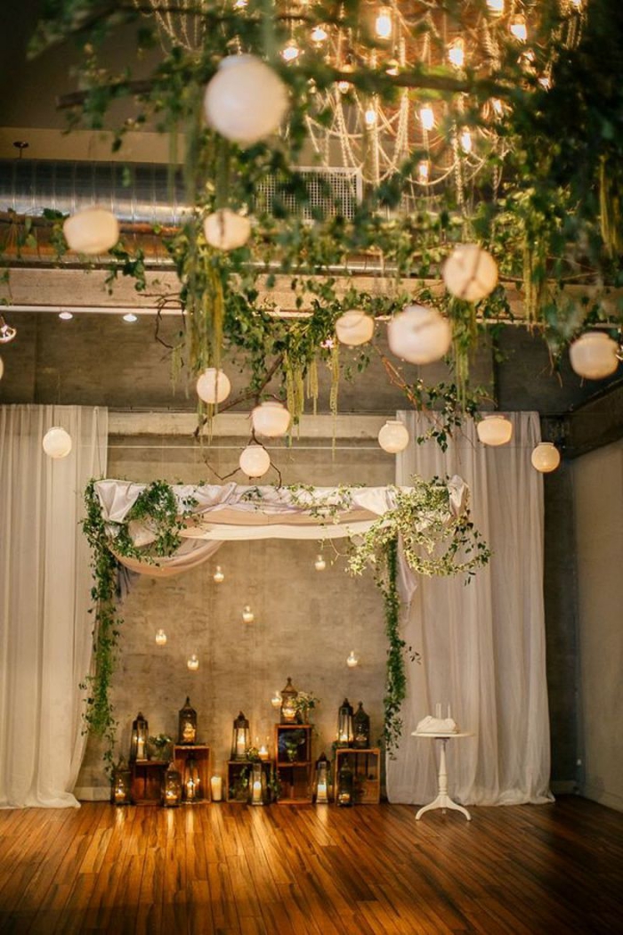 wedding reception décor indoors backdrop branches foliage lanterns and outdoor lights
