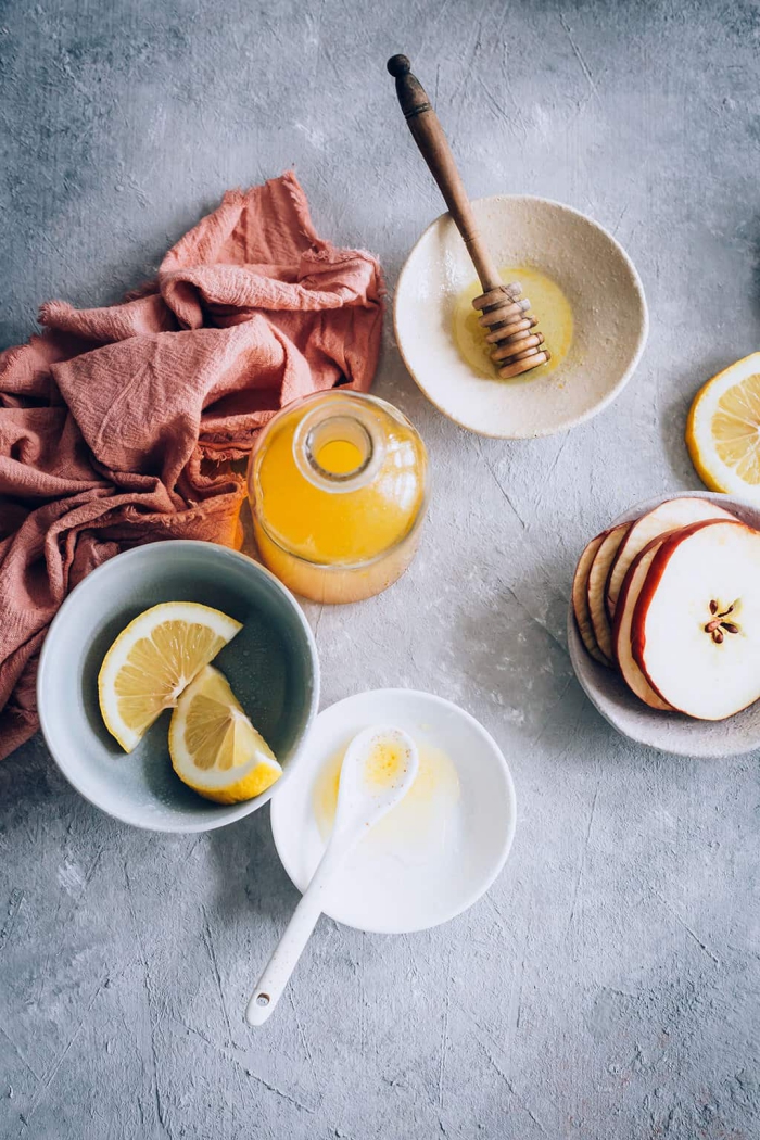 Apple Cider Vinegar bottle slices of lemon slices of apple honey