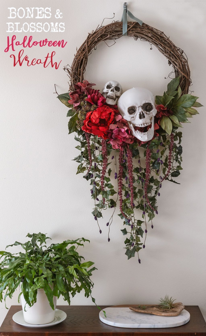 Halloween wreath with two skulls and flowers hanging on a wall