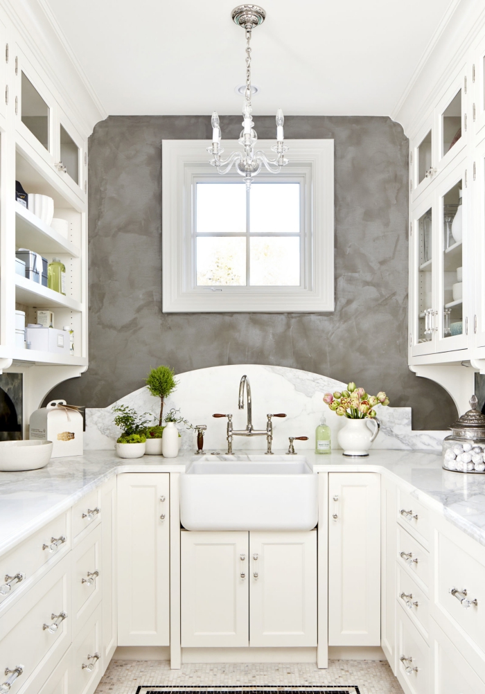 beautiful white and grey galley kitchen with a chandelier