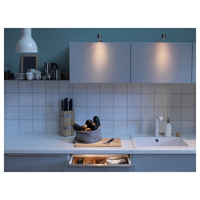 Modern minimal metal kitchen cabinet lights in a small white kitchen