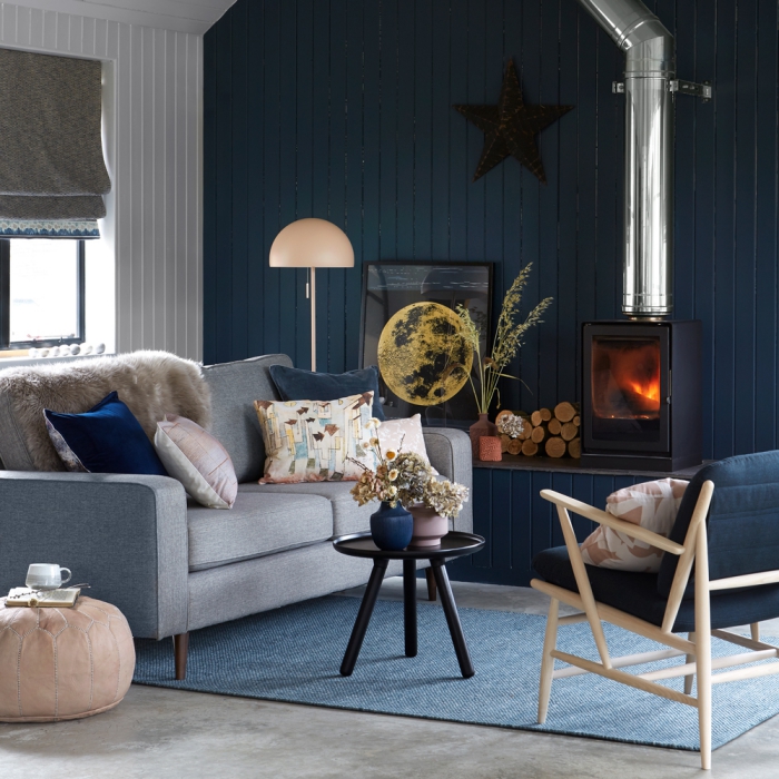 living room interior with a statement dark wall fireplace and grey furniture