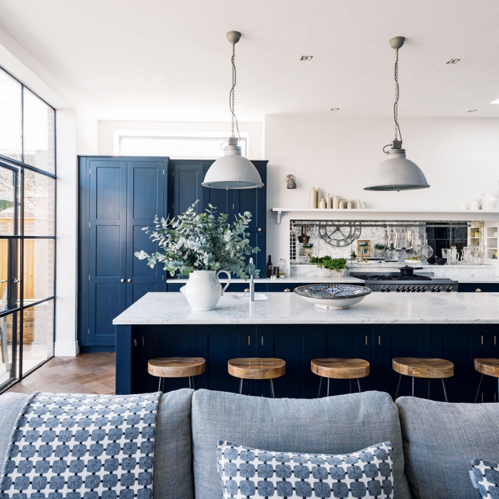 spacious kitchen in navy blue and white metal lamps and kitchen island