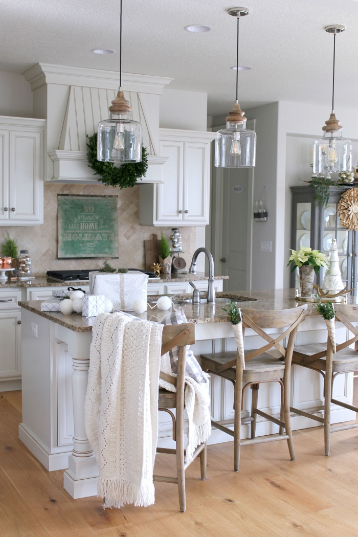 Three pendant lights over kitchen island in white traditional style kitchen interior