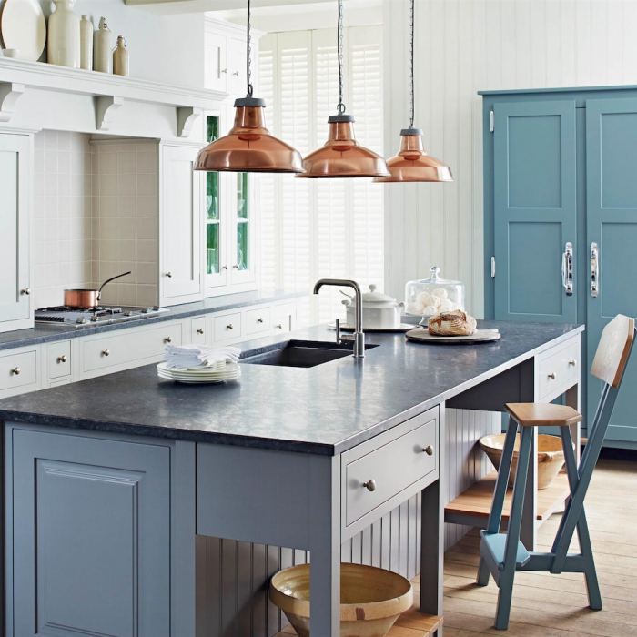 copper metal pendant kitchen lights over a grey kitchen island 