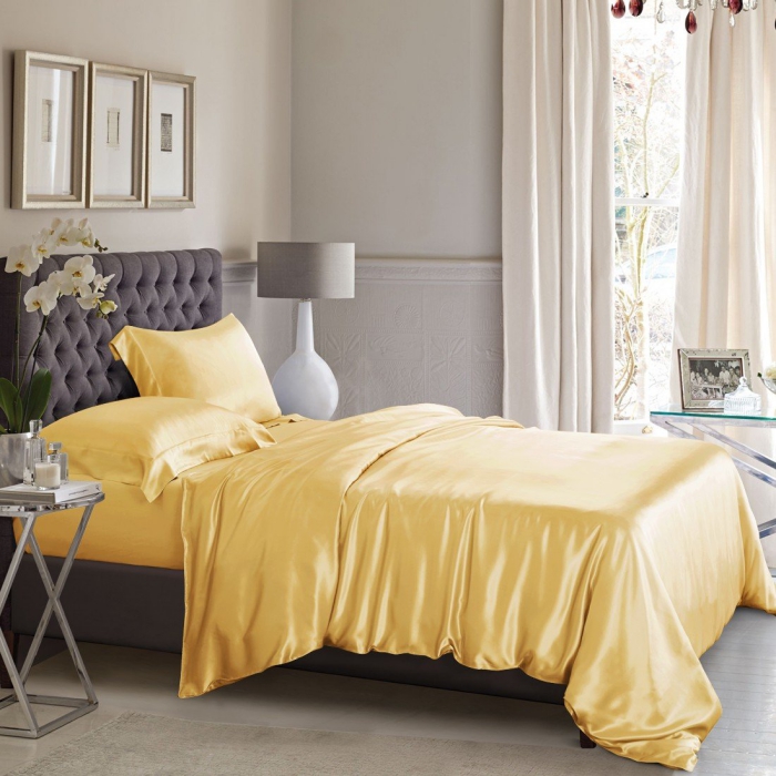 bed in a light room with light yellow high quality silk bedding