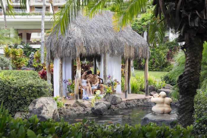 couple enjoying breakfast in a beautiful garden with water pond